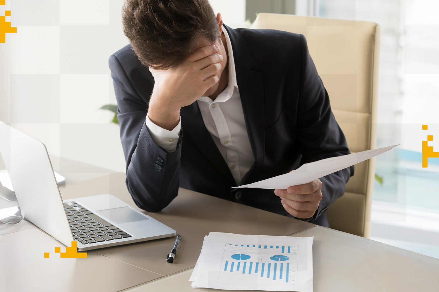 Homem de negócios preocupado com perda de vendas, segurando documento e analisando gráficos financeiros no escritório.